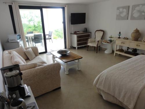 a living room with a bed and a couch and a table at Charmantes chambres 792 Route Inférieure de Cardo in Bastia