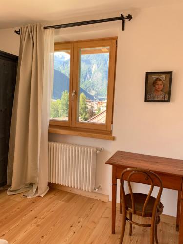 ピンツォーロにあるCasa al Sole Apt. 3のテーブルと窓のあるダイニングルーム