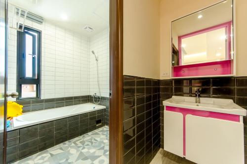 a bathroom with a tub and a sink and a mirror at The Lin Inn in Kenting