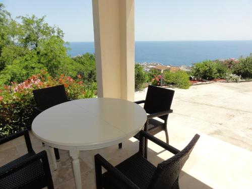 a white table and chairs on a patio with the ocean at Charmantes chambres 792 Route Inférieure de Cardo in Bastia