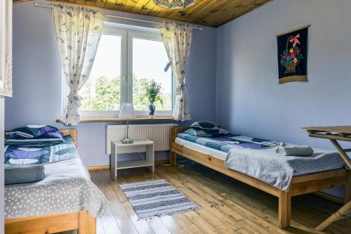 sypialnia z 2 łóżkami i oknem w obiekcie Dom na Starym Gościńcu Tiszyna w mieście Dubicze Cerkiewne