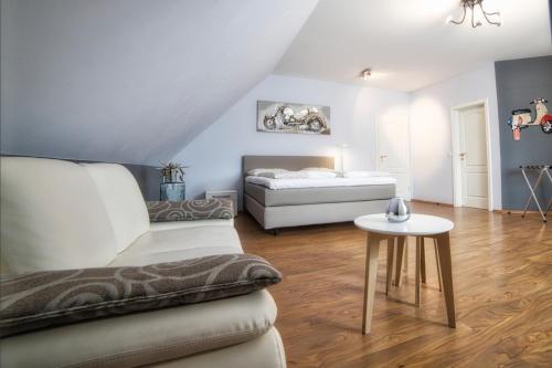 ein Wohnzimmer mit einem Sofa und einem Bett in der Unterkunft Golfhotel Wagenfeld in Wagenfeld