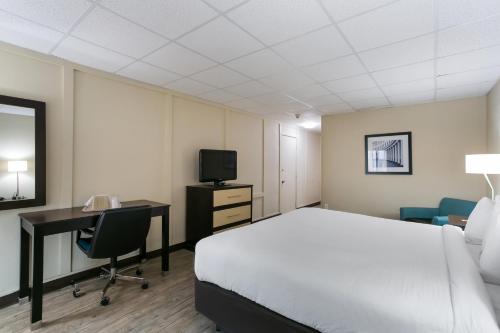 a hotel room with a bed and a desk and a television at Eisenhower Hotel and Conference Center in Gettysburg
