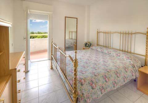 a bedroom with a bed and a mirror and a balcony at Jet Residence Agenzia Riviera del Conero in Porto Recanati