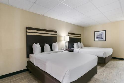 two beds in a hotel room with white sheets at Eisenhower Hotel and Conference Center in Gettysburg