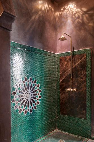 a bathroom with a green tiled wall with a shower at Mumtaz Mahal in Essaouira
