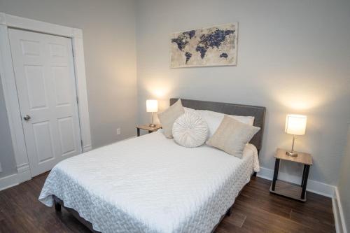 a bedroom with a white bed with two lamps at Remodeled Historic 1BR 1BA House Near Downtown in San Antonio