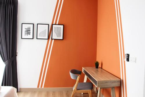 a dining room with orange walls and a wooden table at Bell Suites @ Sunsuria City in Sepang