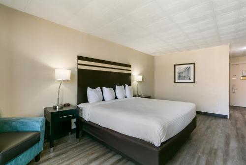 a hotel room with a large bed and a chair at Eisenhower Hotel and Conference Center in Gettysburg