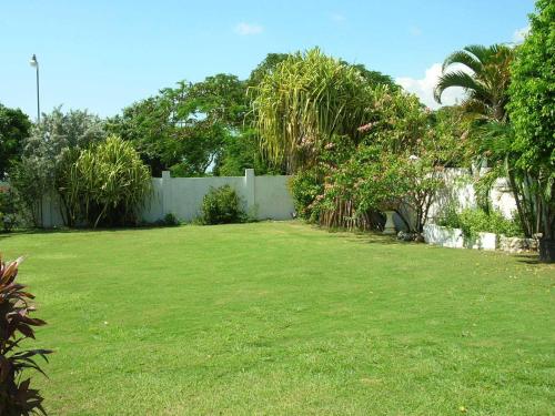 a yard with a fence and green grass at Whispering Bamboo Cove Resort in Belfast