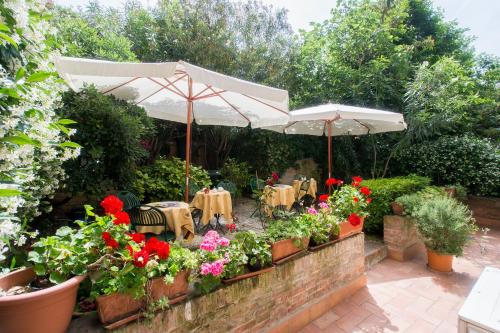 a patio with tables and flowers and an umbrella at Casa Mimma in Venice
