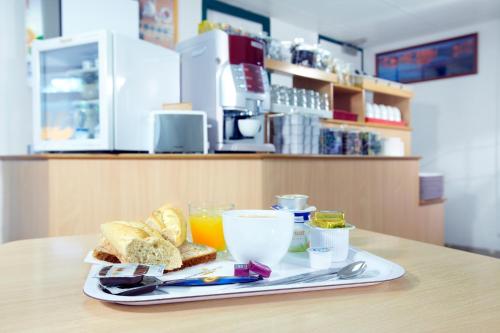 una bandeja de comida con pan y bebidas en una mesa en Premiere Classe Gueret, en Guéret