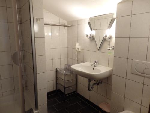 a white bathroom with a sink and a toilet at Pension Dagmar Tauplitz in Tauplitz