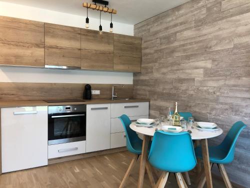 a kitchen with a table and blue chairs at Apartment SCHLADMING - Neualm center in Schladming