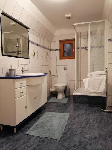 uma casa de banho com um lavatório, um WC e uma banheira em Apartament Harenda em Zakopane
