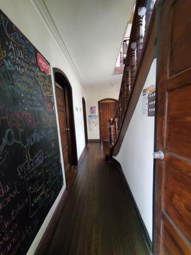 a hallway with a wooden floor and a wall with pictures on it at Hostal CQ Chapinero in Bogotá