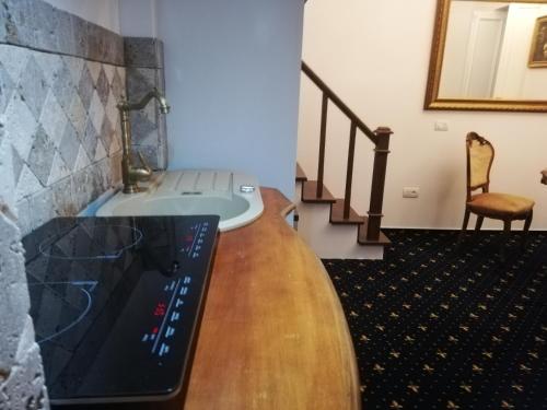 a living room with a wooden table and a staircase at Weiss Little Palace in Braşov