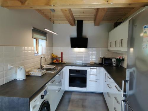 a kitchen with white appliances and wooden ceilings at Agroturystyka Sielanka in Przasnysz