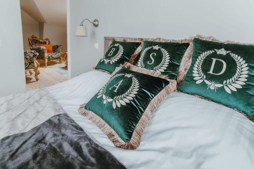 a bed with green and white pillows on it at Baltic Sea Dunes Apartments in Jūrmala