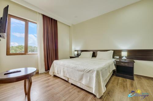 a hotel room with a bed and a table and a window at Mirage Hotel in Shekvetili