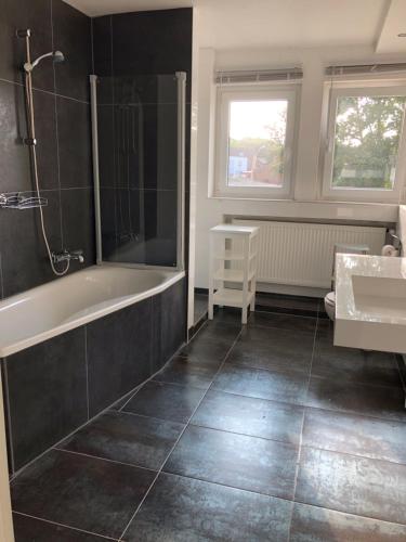 a bathroom with a bath tub and a sink at In der Luft Obergeschoss in Wesel