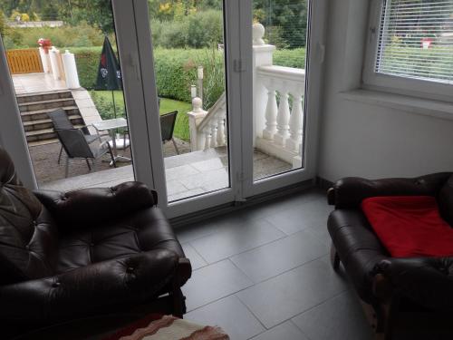 a living room with a couch and sliding glass doors at Pension Dagmar Tauplitz in Tauplitz