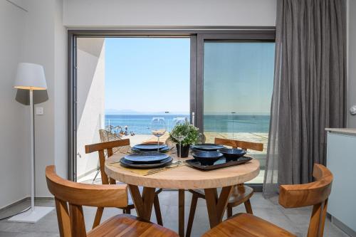 jadalnia ze stołem i widokiem na ocean w obiekcie NOA BEACHFRONT SUITES w Kardamenie