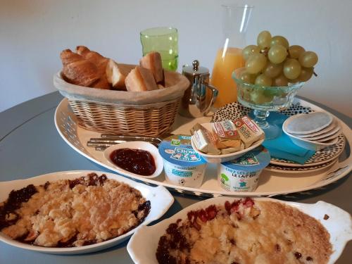 einen Tisch mit zwei Teller Essen und Brot in der Unterkunft Les Hortensias-chambre chez l'habitant in Bretteville-du-Grand Caux