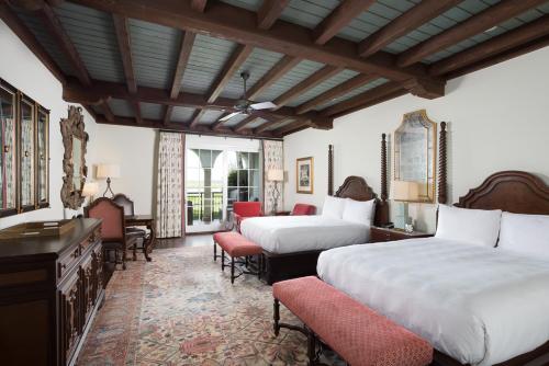 a hotel room with two beds and a desk and chairs at The Cloister in Sea Island