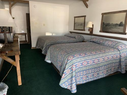 a bed room with two beds and a desk at Bunkhouse motel in Guernsey