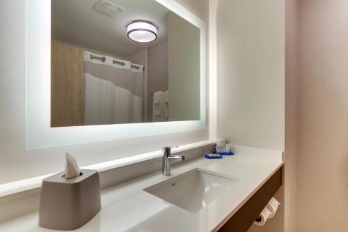 Baño blanco con lavabo y espejo en Holiday Inn Express Hotel & Suites Corbin, an IHG Hotel, en Corbin