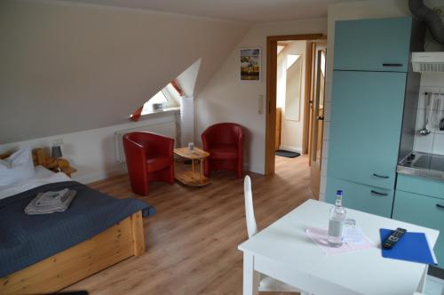 Schlafzimmer mit einem Bett, einem Tisch und Stühlen in der Unterkunft Hotel Südstrand Amrum in Wittdün