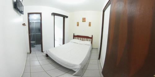 a small bedroom with a bed and a bathroom at Hotel Praia Grande in Penha