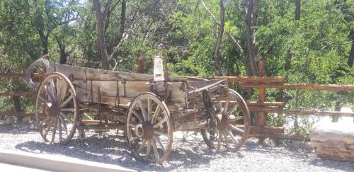 an old wooden wagon sitting next to a fence at Browns Canyon Inn in Salida