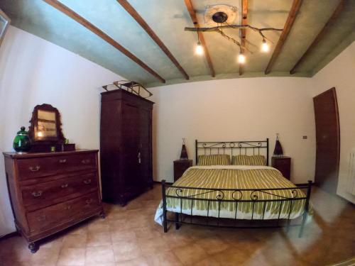 a bedroom with a bed and a dresser in it at Cà di N in Castel dʼAiano