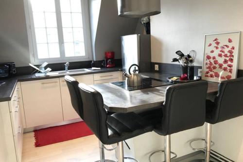 - une cuisine avec une table et une bouilloire dans l'établissement Appartement L'Ormeau 4 étoiles dans le centre historique de Saint Malo, à Saint-Malo