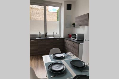une cuisine avec une table avec des assiettes dessus dans l'établissement The blue flat 55m2 à côté de la Gare, à Châlons-en-Champagne
