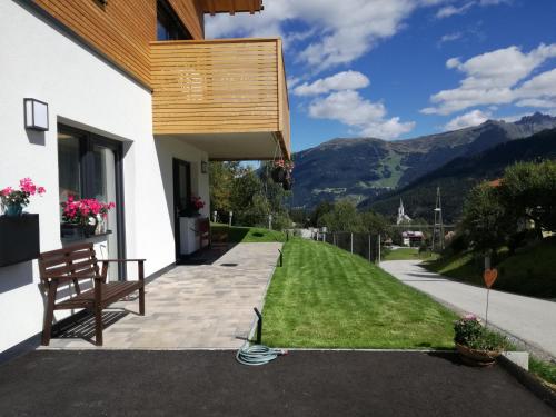 ein Haus mit einem Garten mit einem Schlauch in der Unterkunft Bergperle Apartments & Mountain Sport in Fliess