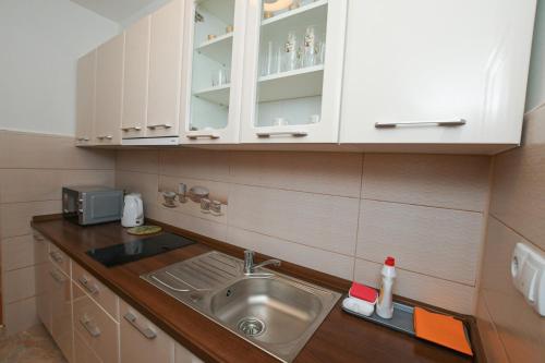 La cuisine est équipée d'un évier et d'un four micro-ondes. dans l'établissement Apartman Netra, à Kladovo