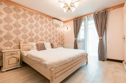 a bedroom with a large bed and a window at Vila Genia in Câmpulung Moldovenesc