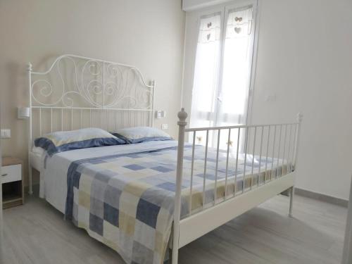 a bedroom with a white bed with a blue and yellow blanket at A due passi in San Pietro in Bevagna