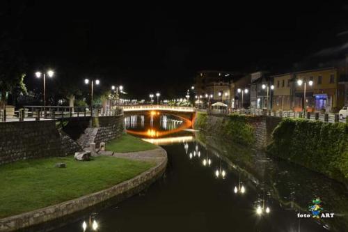 a bridge over a river at night with lights at Privatan smestaj knjazevac in Knjazevac.