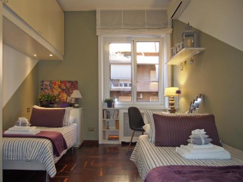 a living room with two beds and a window at Holiday in Rome in Rome
