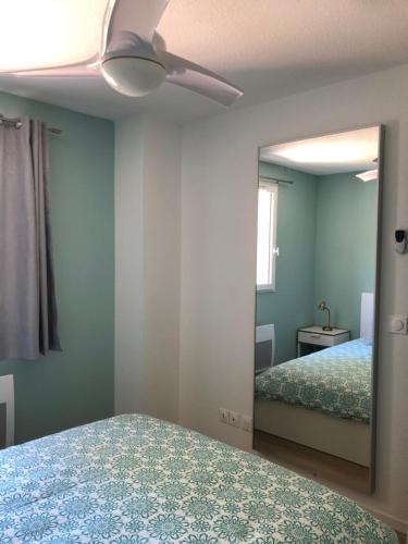 - une chambre avec un miroir et un ventilateur de plafond dans l'établissement Résidence Mas les Cigales 3 étoiles, à Castries