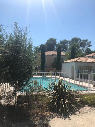 une piscine entourée d'une clôture blanche. dans l'établissement Résidence Mas les Cigales 3 étoiles, à Castries