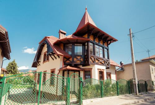 een huis met een groen hek ervoor bij Vila Genia in Câmpulung Moldovenesc