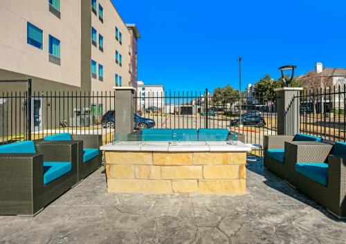 a patio with chairs and a table in front of a fence at La Quinta Inn & Suites DFW West-Glade-Parks in Euless