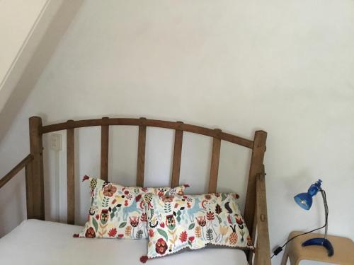 - une chambre avec un lit en bois et un oreiller dans l'établissement Tuinzicht, à Vorden