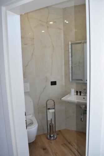 a bathroom with a toilet and a sink at COSMO Beach Hotel in Durrës