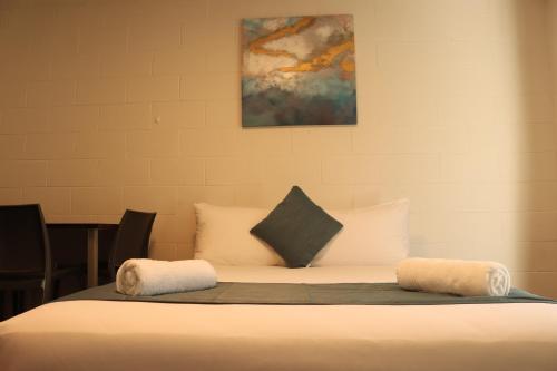 a bed with two pillows on top of it at Victoria Apartments in Hamilton